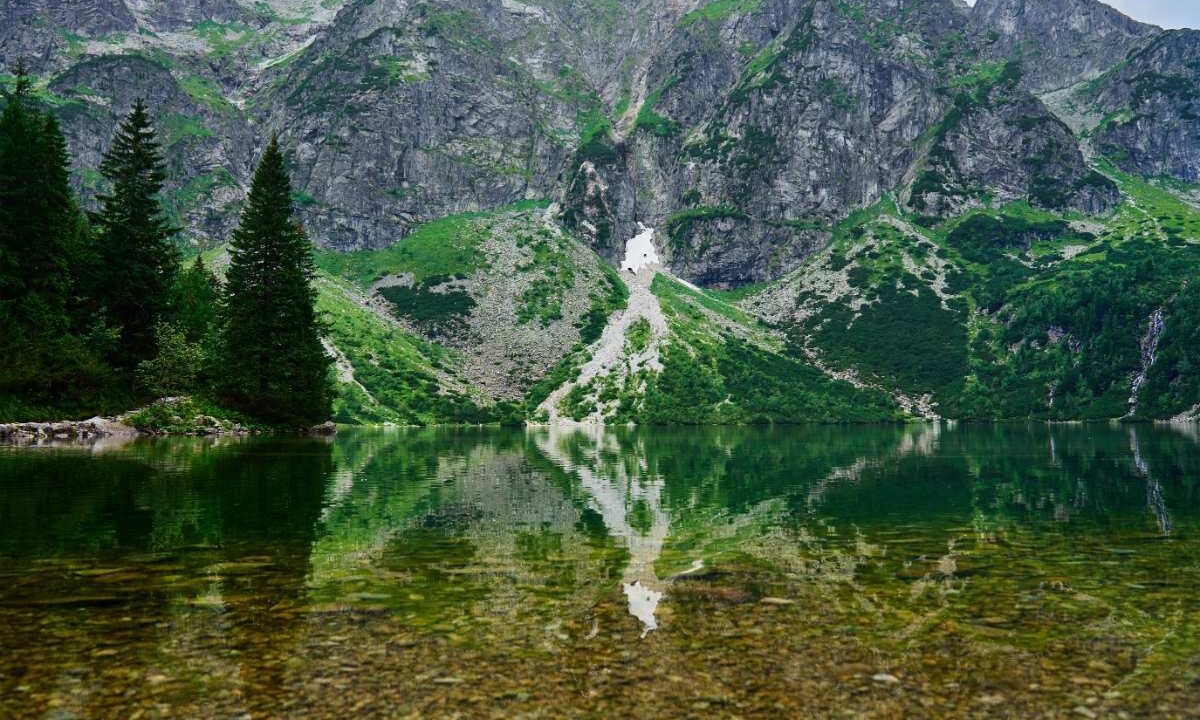 Morskie Oko w Tatrzańskim Parku Narodowym, w tafli jeziora odbijają się szczyty Tatr