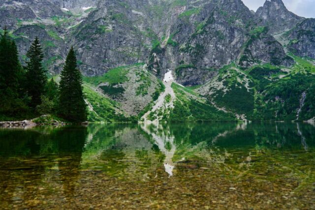 Morskie Oko w Tatrzańskim Parku Narodowym, w tafli jeziora odbijają się szczyty Tatr