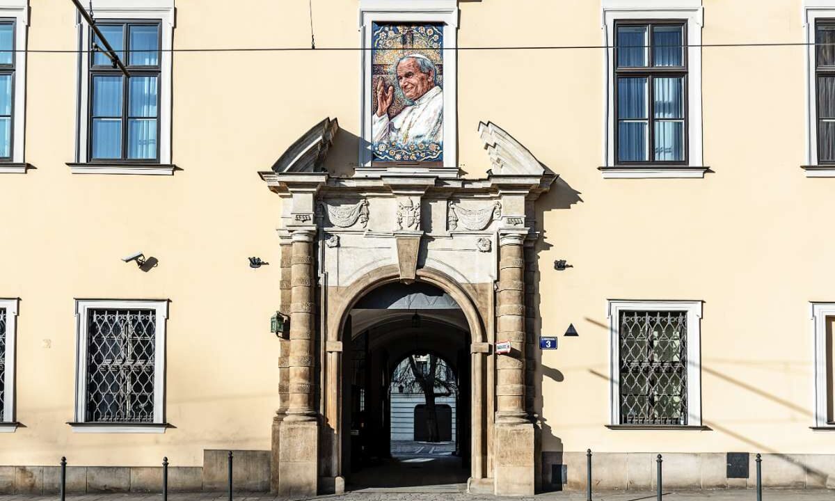 Pałac Biskupi przy ulicy Franciszkańskiej w Krakowie z portretem Jana Pawła II w oknie papieskim nad bramą