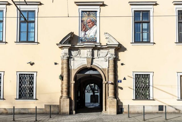 Pałac Biskupi przy ulicy Franciszkańskiej w Krakowie z portretem Jana Pawła II w oknie papieskim nad bramą