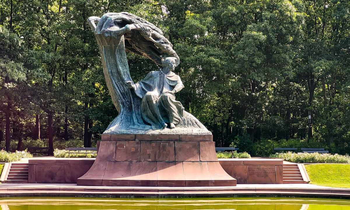Pomnik Fryderyka Chopina z rzeźbioną wierzbą w parku Łazienki Królewskie w Warszawie, przed nim sadzawka