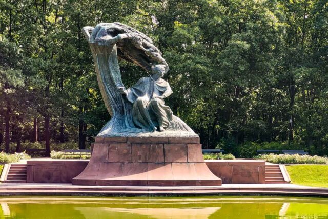 Pomnik Fryderyka Chopina z rzeźbioną wierzbą w parku Łazienki Królewskie w Warszawie, przed nim sadzawka