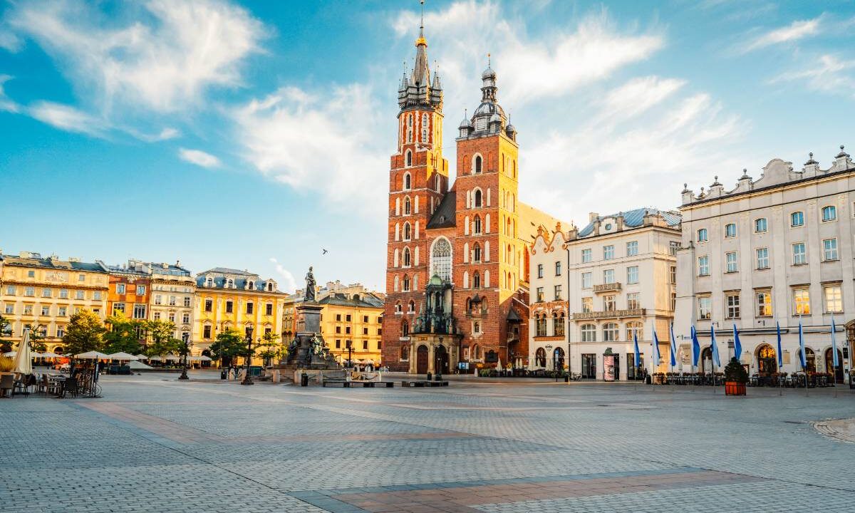 Rynek Główny w Krakowie z Bazyliką Mariacką i kamienicami w słoneczny dzień
