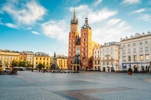 Rynek Główny w Krakowie z Bazyliką Mariacką i kamienicami w słoneczny dzień