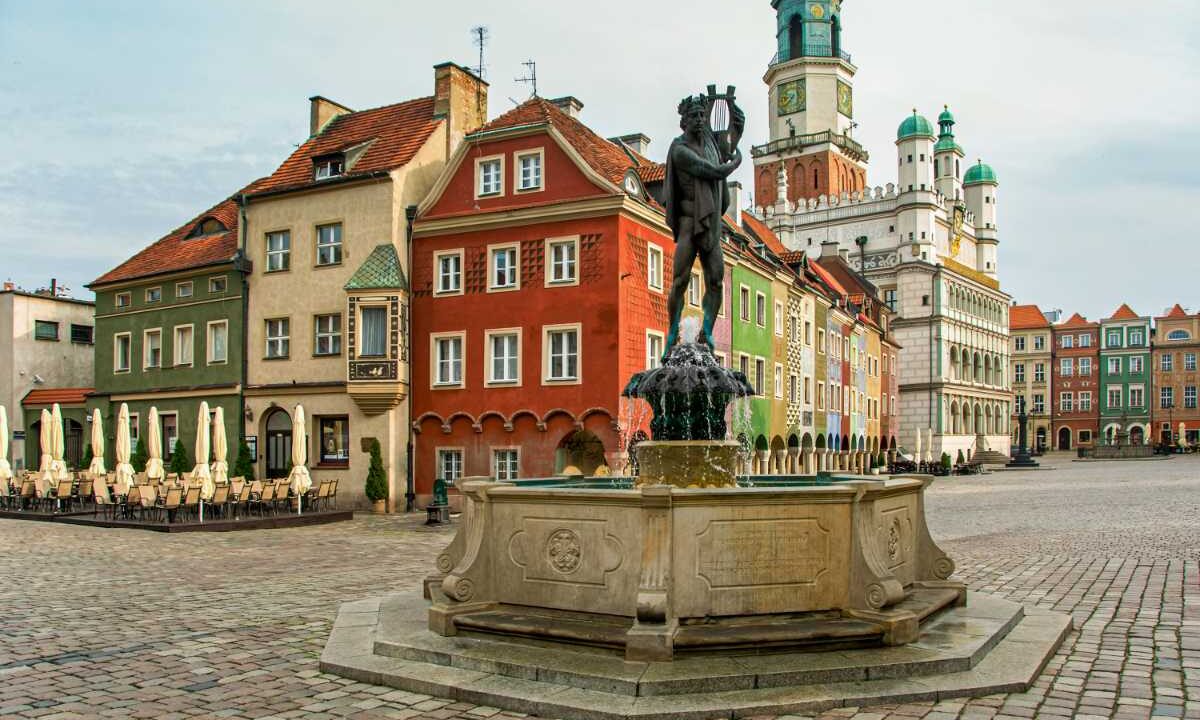 Stary Rynek w Poznaniu: kolorowe kamieniczki, fontanna z posągiem i wieża ratusza