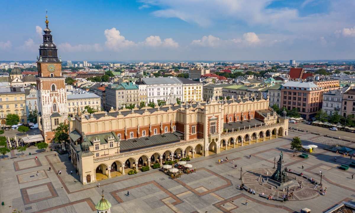 Widok z lotu ptaka na Rynek Główny w Krakowie z Sukiennicami, wieżą ratuszową i pomnikiem Adama Mickiewicza w słoneczny dzień