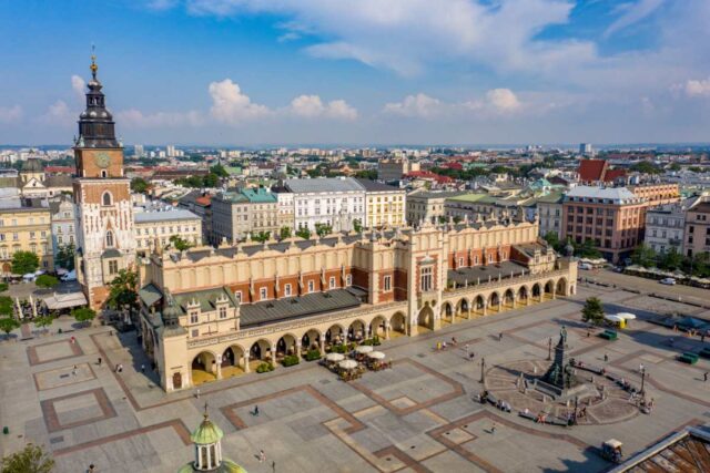 Widok z lotu ptaka na Rynek Główny w Krakowie z Sukiennicami, wieżą ratuszową i pomnikiem Adama Mickiewicza w słoneczny dzień